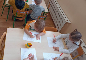 Dzieci wykonują przy stolikach pracę grafomotoryczną - godło Włoch
