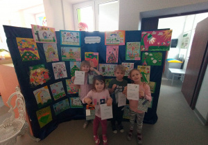 zdjęcie przedstawia nagrodzone w konkursie dzieci, dzieci stoją przy wystawie prac konkursowych