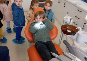 Chłopiec siedzi na fotelu dentystycznym