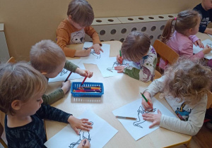 Dzieci kolorują rysunek bociana