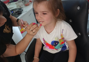 dziewczynka podczas malowania ust