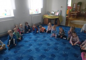 dzieci siedzą na dywanie