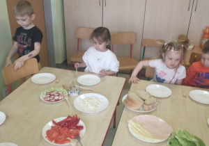 dzieci siedzą przy stoliku, dzieci przygotowują kanapki