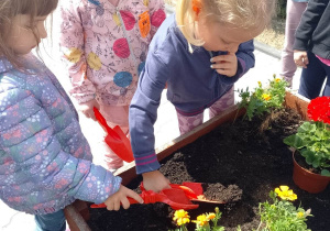 Dziewczynki szykują gazony do sadzenia kwiatów