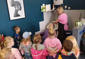 dzieci oglądają jak fryzjerka myje głowę