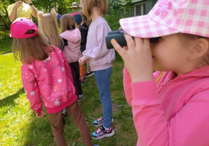 dzieci obserwują przyrodę przez lornetki