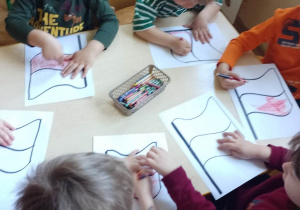 Dzieci kolorują flagę Polski - wypełniają kontury kredkami