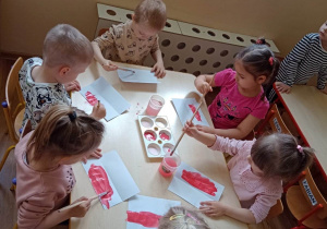 Dzieci malują farbami flagę Polski