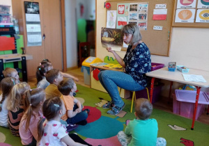 Nauczycielka czyta dzieciom legendę o Smoku Wawelskim
