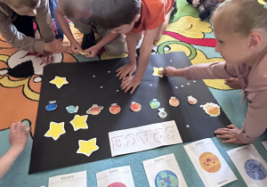 dzieci wykonują plakat przedstawiający kosmos