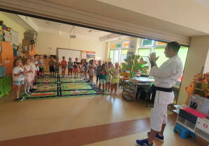Pan Łukasz opowiada dzieciom o swojej pasji i zachęca do udziału w zajęciach karate