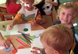 Dzieci w skupieniu tworzą gąsienicę z kolorowych kół