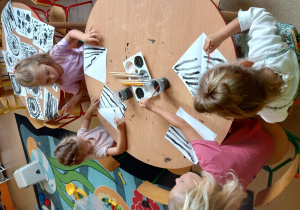 Dzieci malują abstrakcyjne obrazy po wcześniejszym zapoznaniu się ze sztuką optyczną
