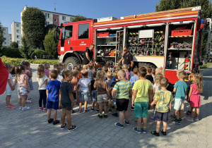 Dzieci oglądają wóz strażacki i jego wyposażenie