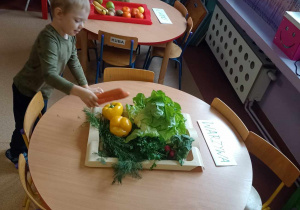 Chłopiec segreguje warzywa