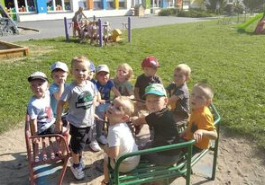 Dzieci kręcą się na karuzeli w ogrodzie przedszkolnym.