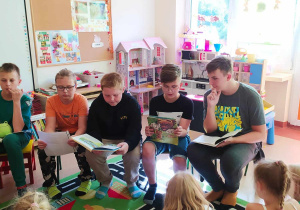 uczniowie szkoły czytają dzieciom wiersze