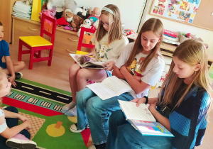 uczennice szkoły czytają dzieciom opowiadania