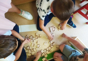 dzieci układają litery z klocków