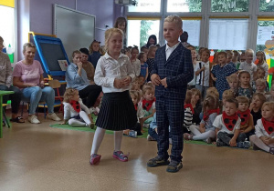 Dziewczynka i chłopiec mówią wiersz skierowany do nauczycielek