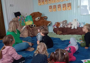 Dzieci w skupieniu słuchają opowiadania czytanego przez panią Olę