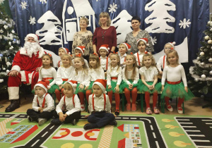 Zdjęcie grupowe dzieci z Mikołajem, wychowawczynią i panią dyrektor
