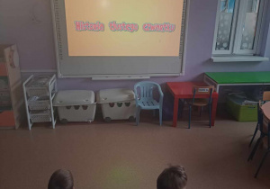 Dzieci poznają historię Tłustego Czwartku oglądając film edukacyjny na tablicy multimedialnej