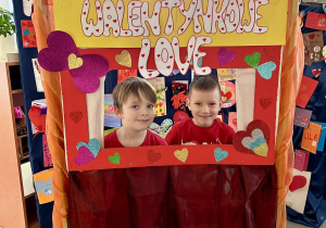 Dzieci pozują do zdjęcia w fotobudce Walentynkowe Love