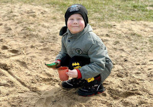 Chłopiec bawi się piaskiem
