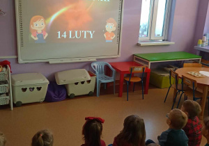Dzieci oglądają film na tablicy multimedialnej o Walentynkach