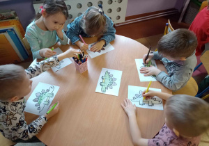 Dzieci kolorują dinozaura wg wzoru