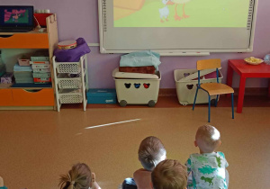 Dzieci oglądają na tablicy multimedialnej baśń "Brzydkie Kaczątko"