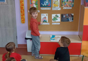 Chłopiec prawidłowo rozwiązuje zagadkę słowną wskazując obrazkowe rozwiązanie na tablicy