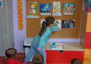 Dziewczynka prawidłowo rozwiązuje zagadkę słowną wskazując obrazkowe rozwiązanie na tablicy