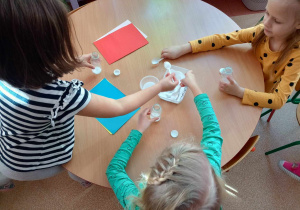 Dzieci wypełniają plastikowe butelki solą tworząc własny instrument