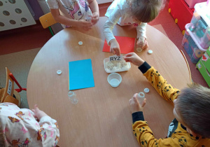 Dzieci wypełniają plastikowe butelki ryżem tworząc własny instrument