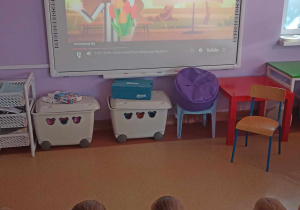 Dzieci oglądają na tablicy multimedialnej film edukacyjny o Dniu Kobiet