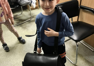 Chłopiec z torbą i czapką listonosza
