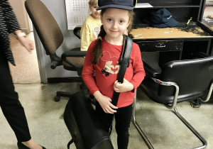Dziewczynka z torbą i czapką listonosza