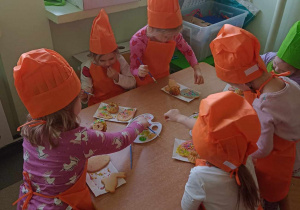 Dziewczynki dekorują ciasteczka kolorową posypką