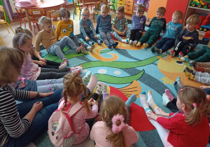 Dzieci w kole wraz z wychowawczynią prezentują kolorowe skarpetki na znak jedności z ludźmi z Zespołem Downa