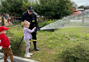 Dzieci leją wodą z węża strażackiego