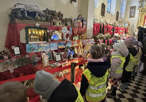 Dzieci z zachwytem oglądają Szopki Bożonarodzeniowe i ozdoby świąteczne