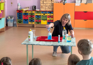 Nauczycielka pokazuje dzieciom efekt końcowy doświadczenia "Wulkan"